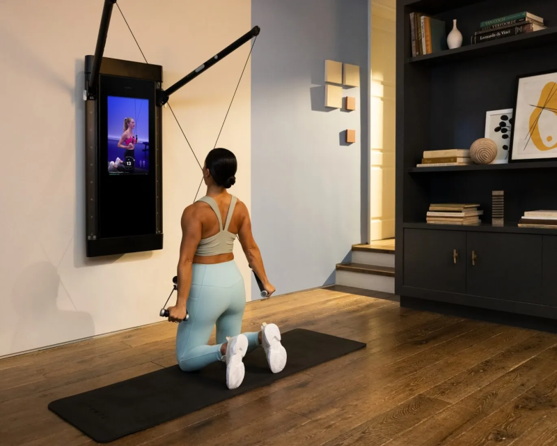 Woman using Tonal home gym with adaptive weight system