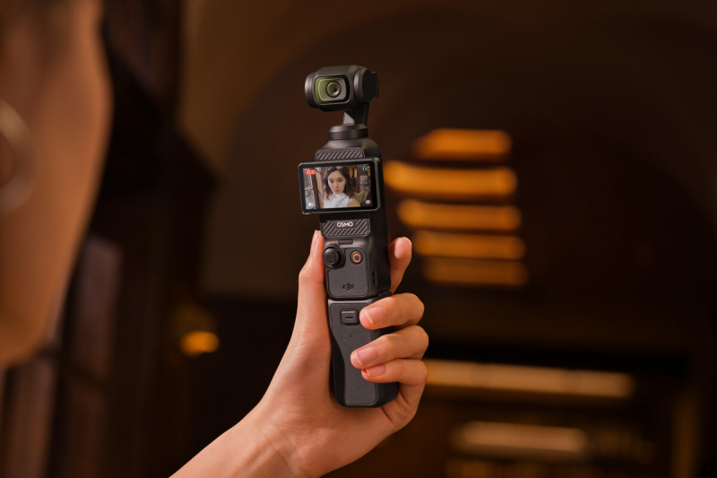 Person holding DJI Osmo Pocket 3 vlogging camera in selfie mode