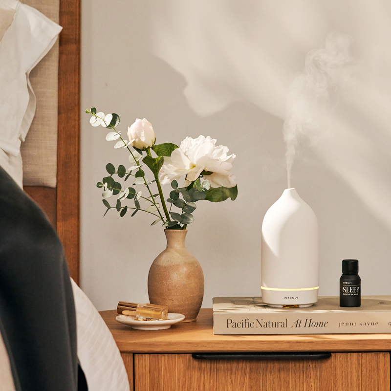 Stone diffuser sitting on a bedside table next to a bed